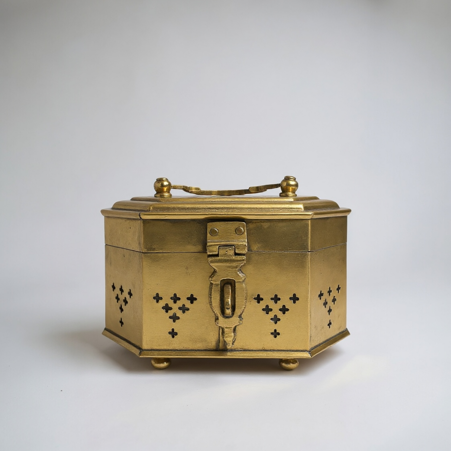 Gold decorative box with intricate designs on a white background