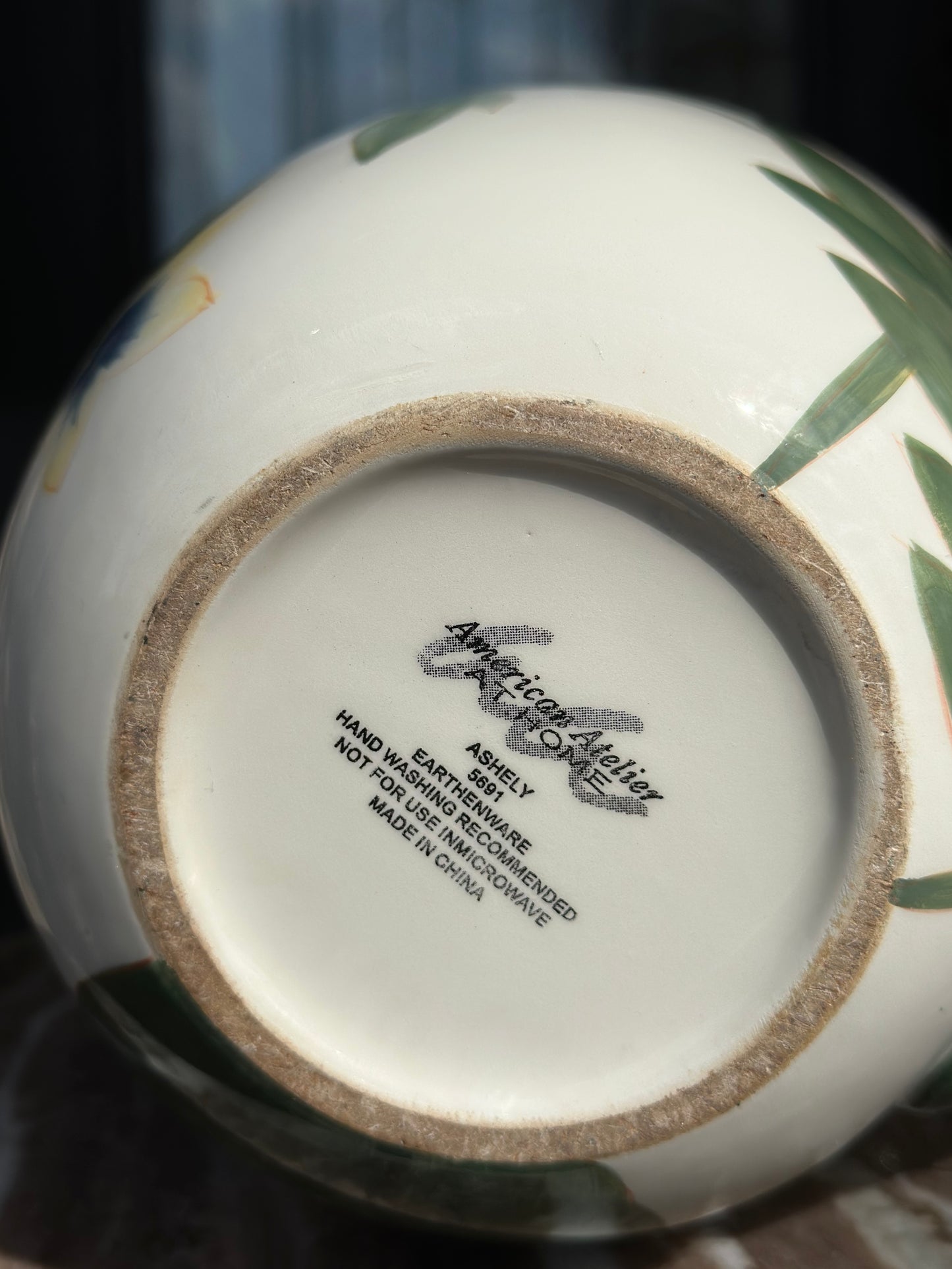Ceramic product with 'American Artelier' branding on a blurred background