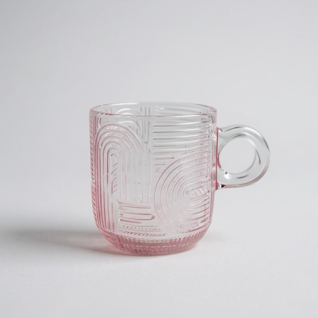 Clear glass mug with pink tint and geometric patterns on a light gray background

