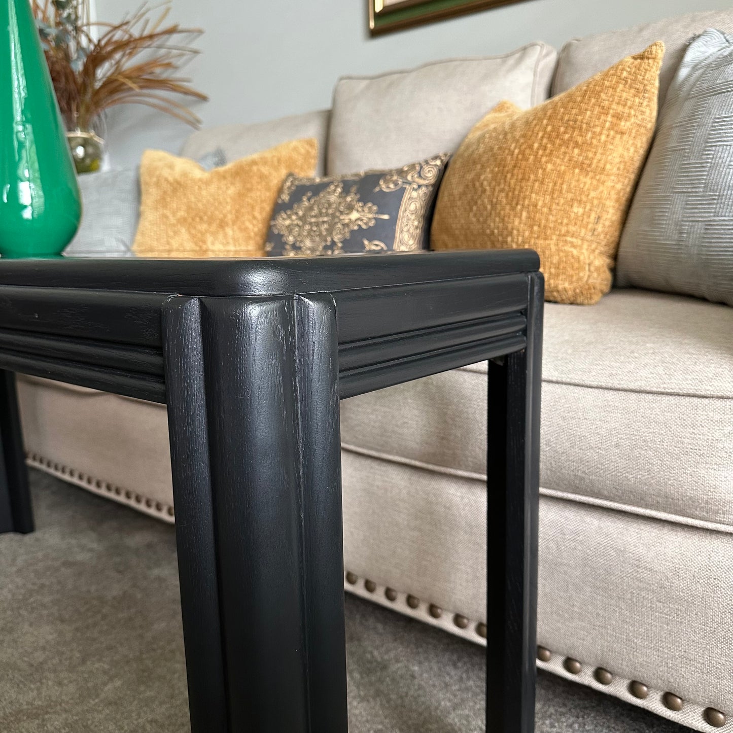 Side view of vintage black console table with fluted legs