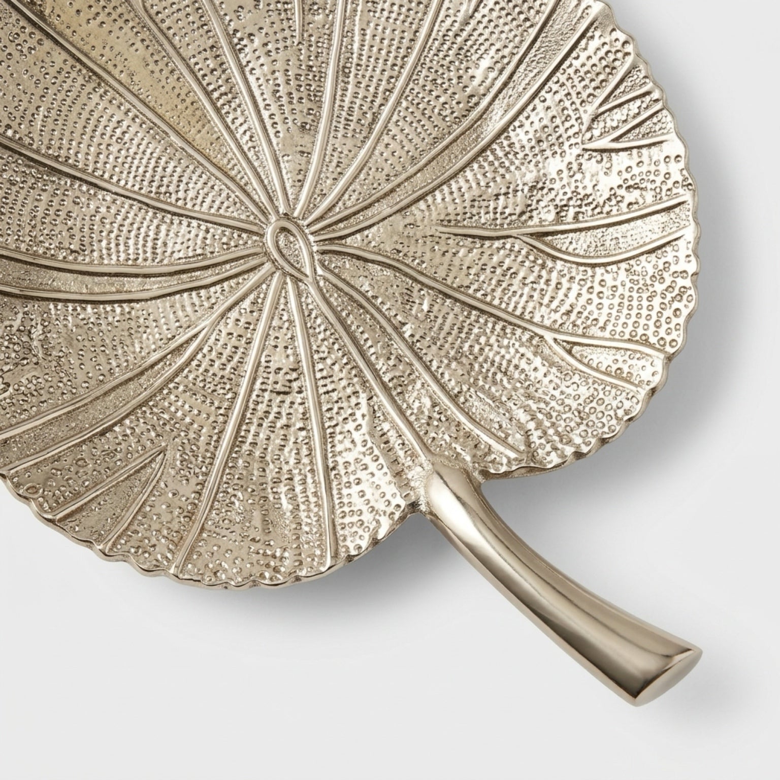 Decorative leaf-shaped plate with textured surface and handle on a white background