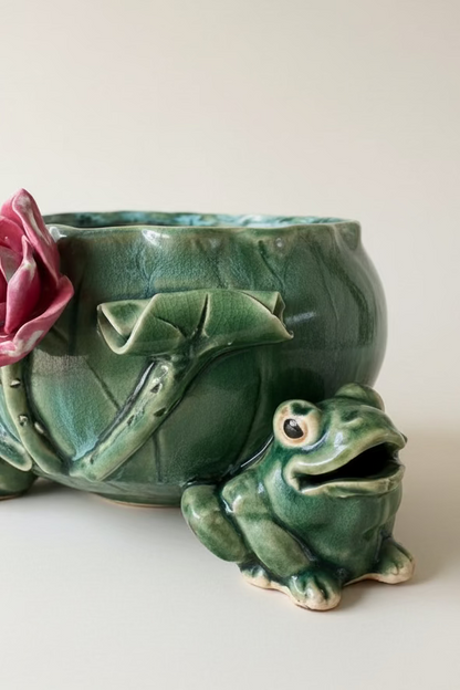 Detailed close up of a glossy green glazed ceramic frog foot with open mouth on a vintage mid century lotus leaf centerpiece bowl.