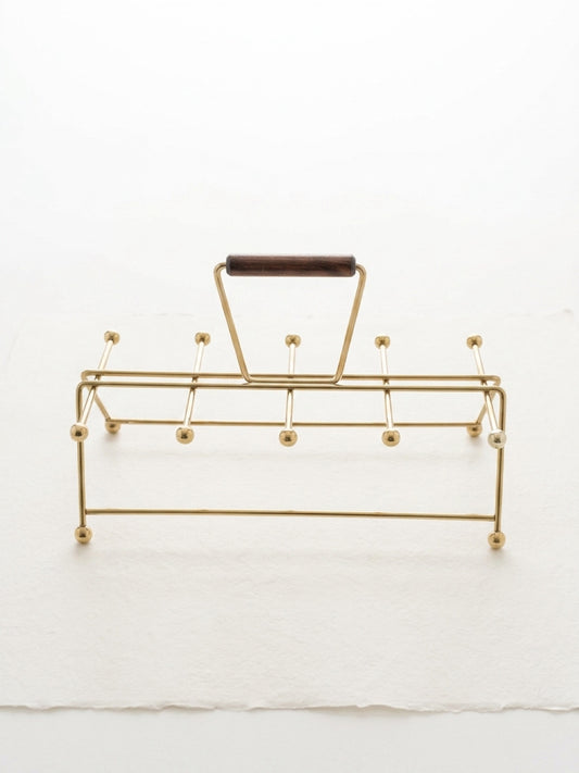 Gold vintage mid century modern atomic age drink carrier with a wooden handle on a white background