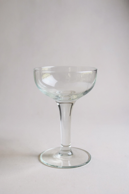 Clear glass coupe on a light gray background

