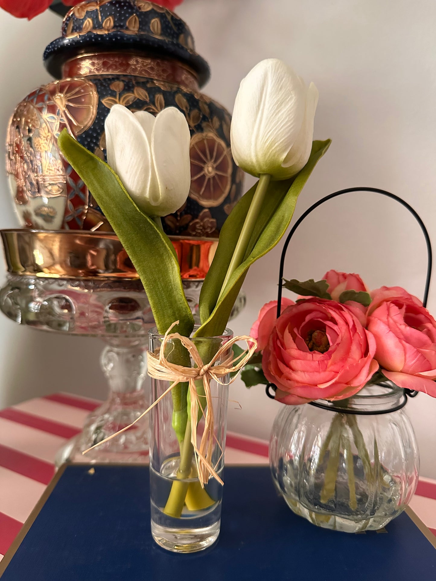 Decorative still life with artificial white tulip flowers and glassware on a table