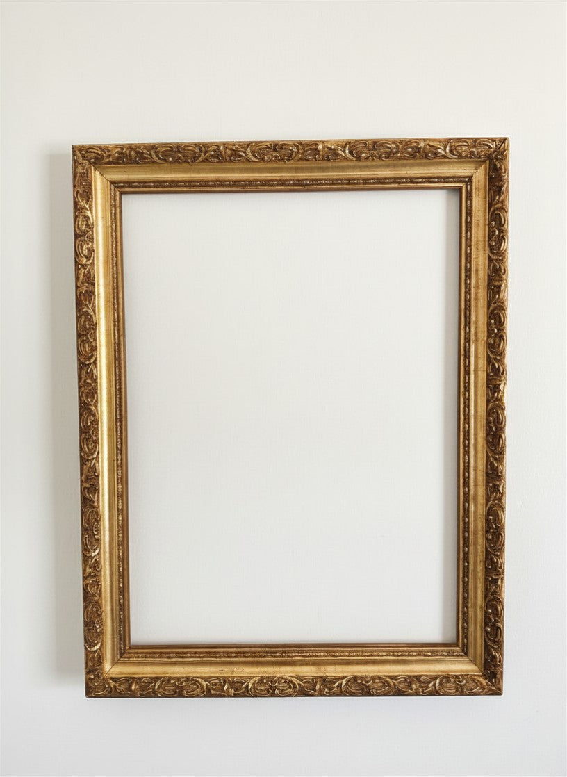 Front view of an empty vintage ornate picture frame from The Marian Collection, finished in a deep antiqued gilded gold with heavy scrollwork detailing. Outer dimensions measure 27.5 x 22 inches, designed to fit 24 x 18 inch art prints or landscape canvases. Beautiful addition for modern heritage and maximalist wall decor.