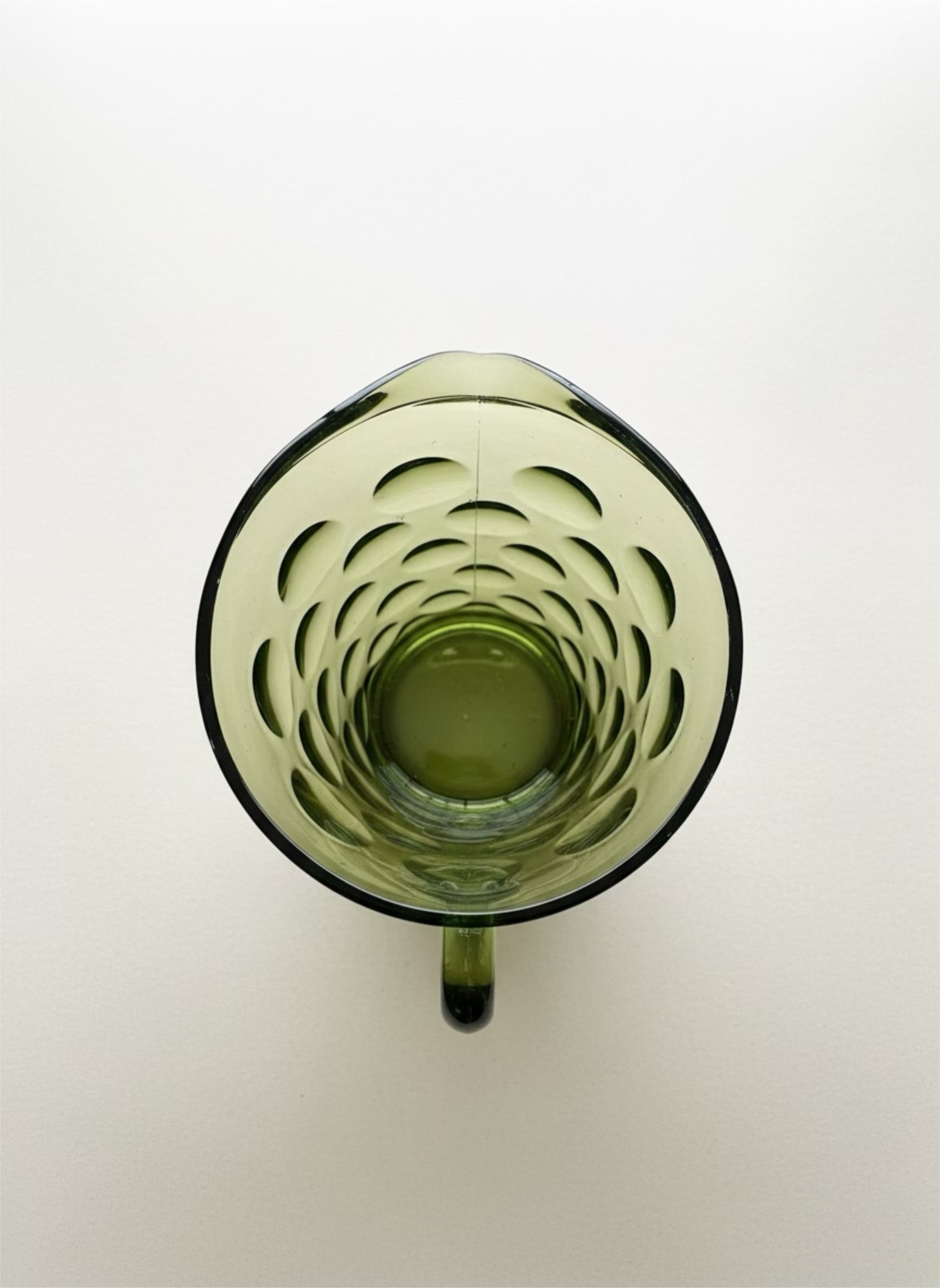 Green glass mug with a unique interior design on a white background