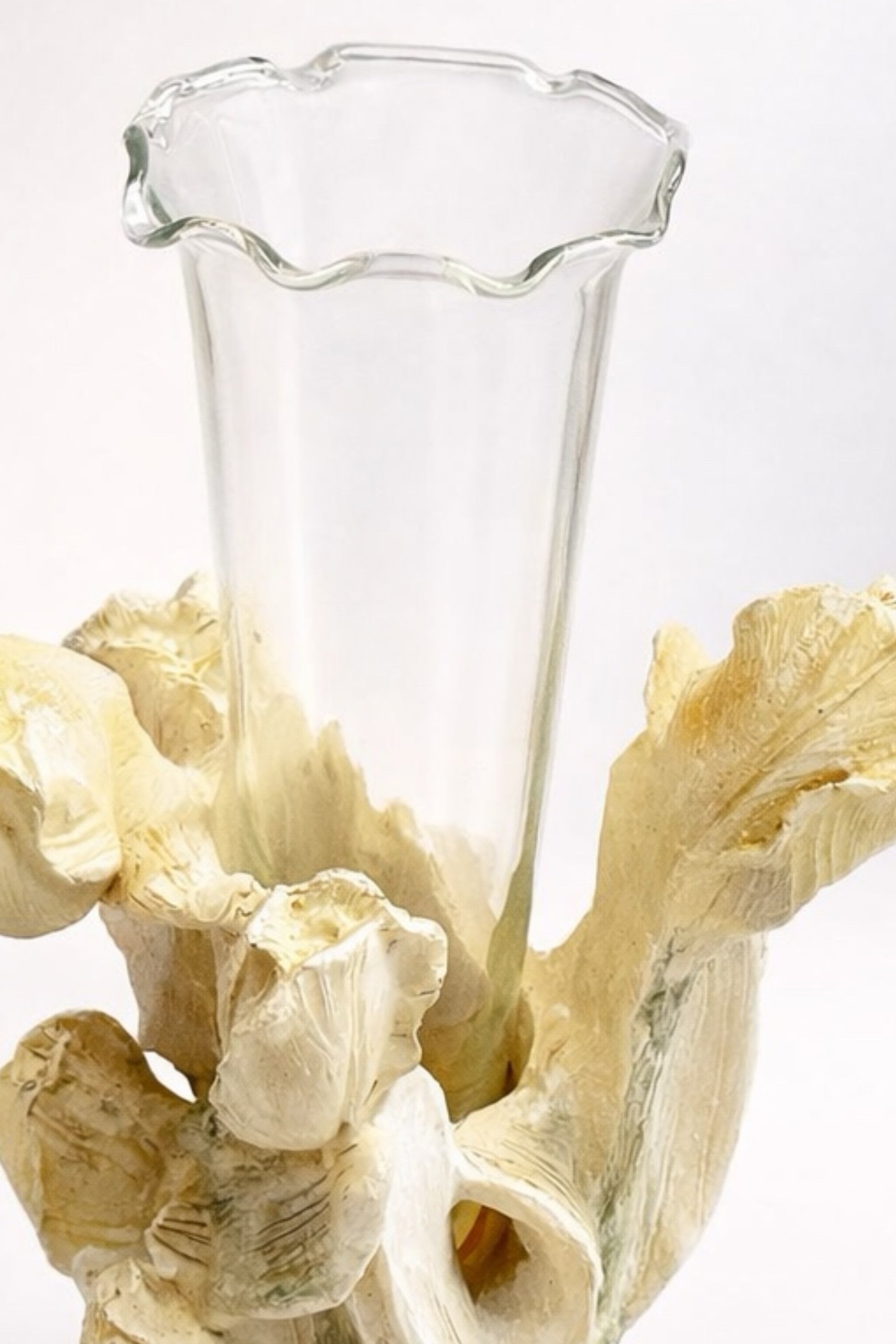 Clear glass vase on a decorative stone base with a white background