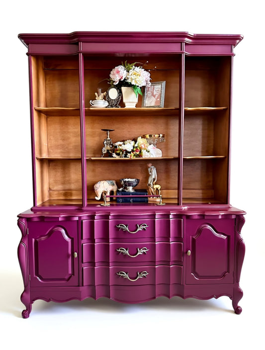 Burgundy and wooden cabinet with decorative items on a white background