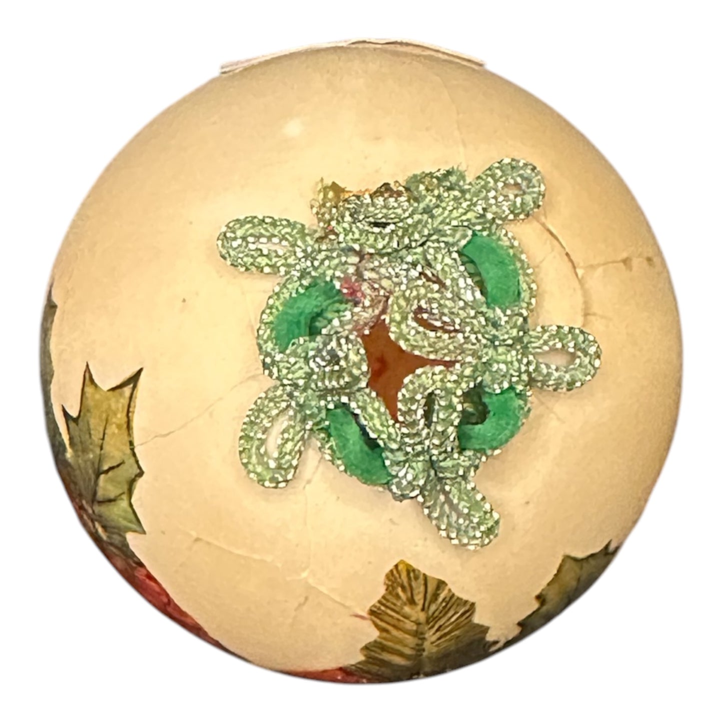 Decorative ball with green beaded design on a white background