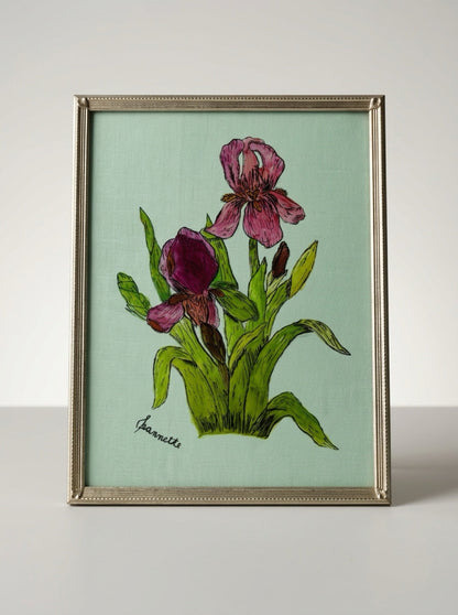  Pink and purple irises with green leaves on a mint background, signed Jeannette, in a slim brass-tone frame.