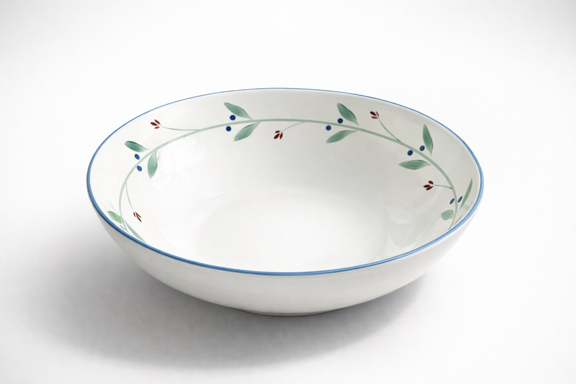 Dansk Portugal XL pasta bowl with botanical rim pattern of green leaves, blue berries, and red buds, photographed on white background for catalog or resale