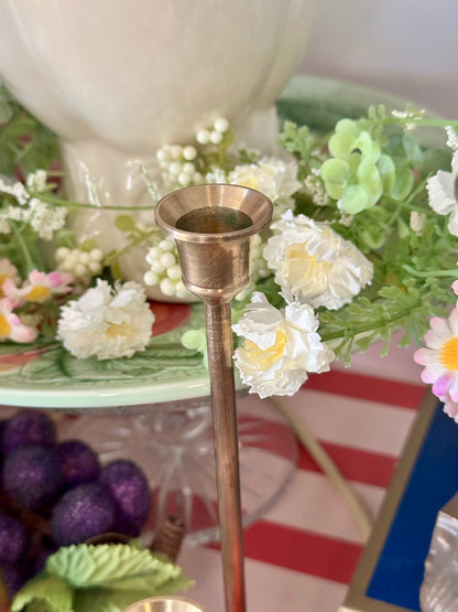 Bronze candle holder with flowers on a decorative table
