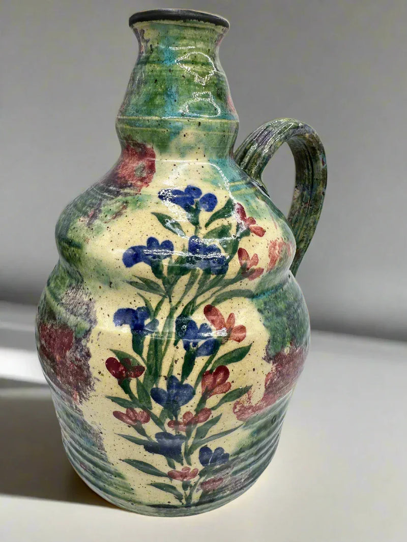 Handcrafted ceramic pitcher with floral design, multicolored, perfect for home decor or serving.
