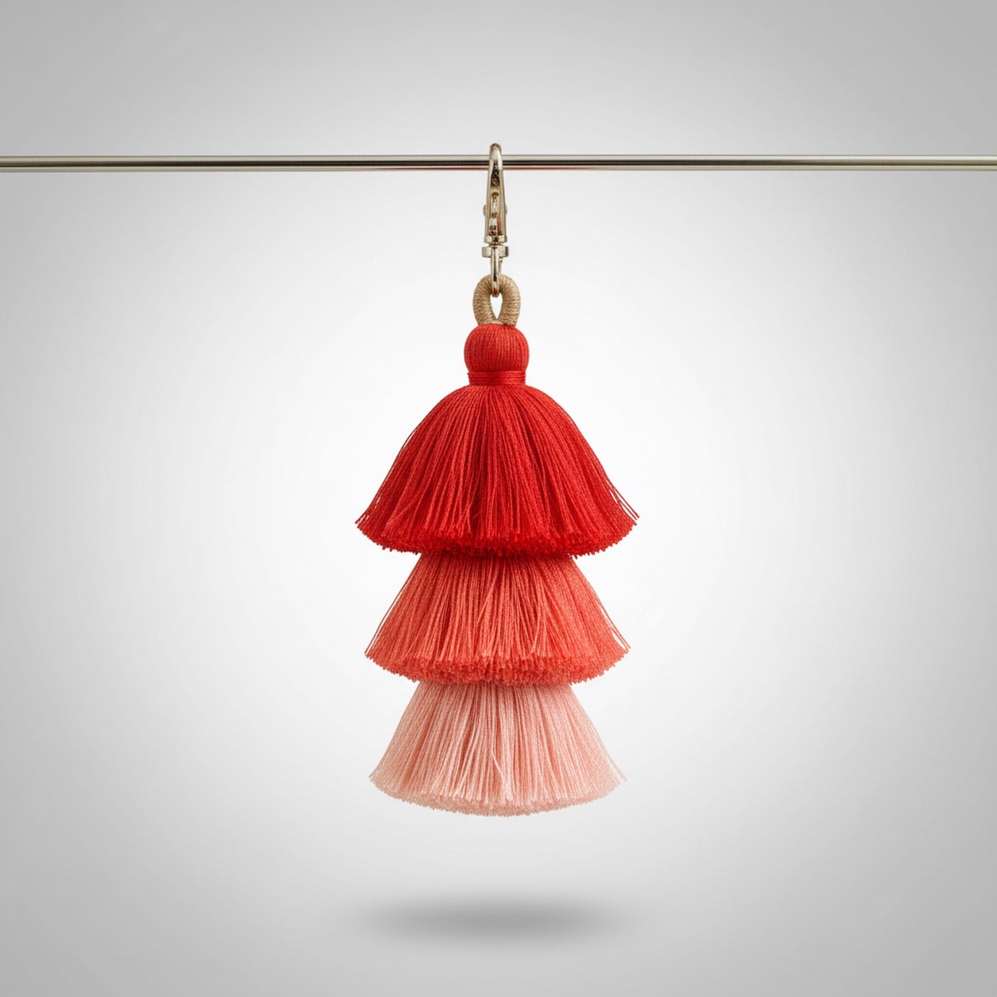 Red and pink tassel earring on a gray background