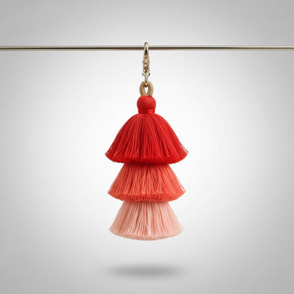 Red and pink tassel earring on a gray background