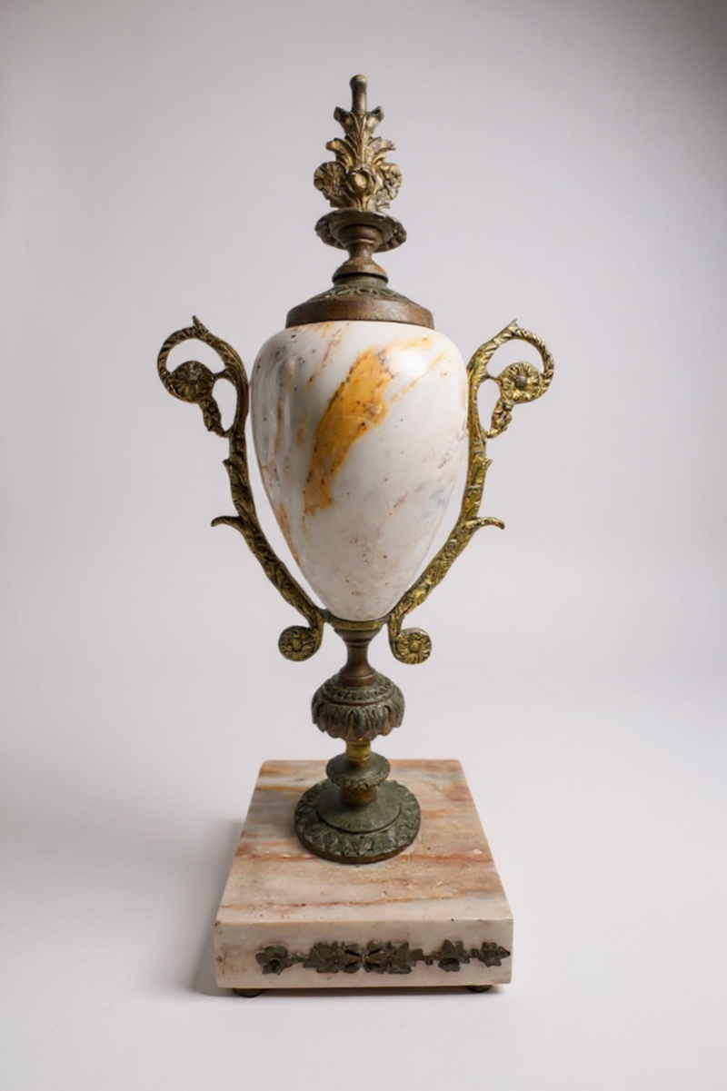 Decorative marble urn with bronze accents and a floral pedestal base, elegant home decor piece.