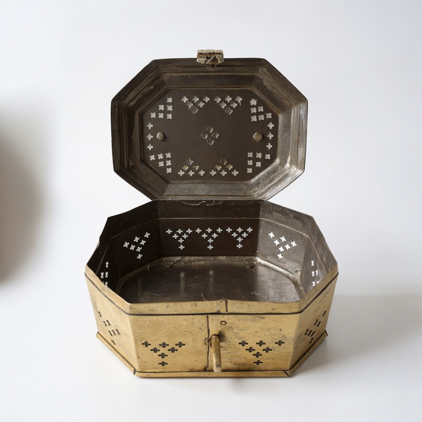 Decorative metal box with intricate designs on a white background