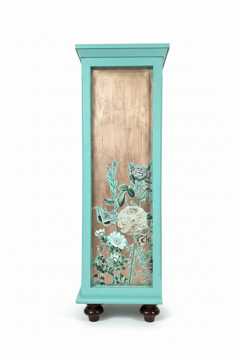 Right side recessed panel view of the Laurentine teal bookshelf, showcasing intricate old-world craftsmanship. The panel features hand-applied shimmering copper metal leafing decorated with moody, high-contrast botanical floral transfers, including white and teal roses, dense greenery, and delicate butterfly motifs, embodying a luxe maximalist and Dark Academia aesthetic.