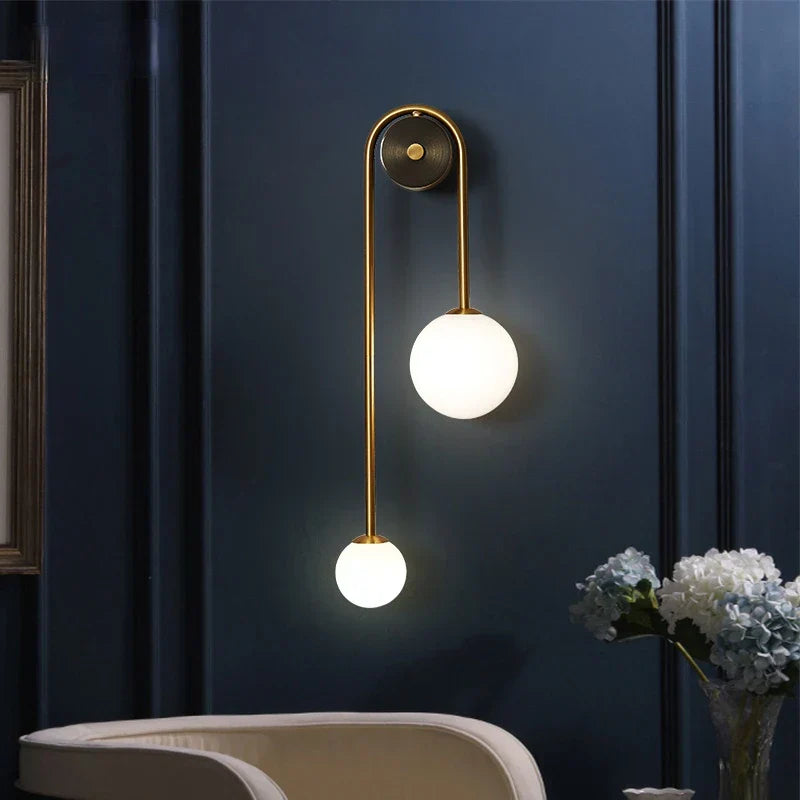 Wall-mounted lamp with two illuminated lights on a dark blue wall.
