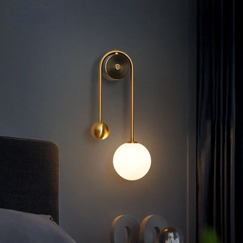 Modern wall lamp with a round bulb on a dark gray wall.
