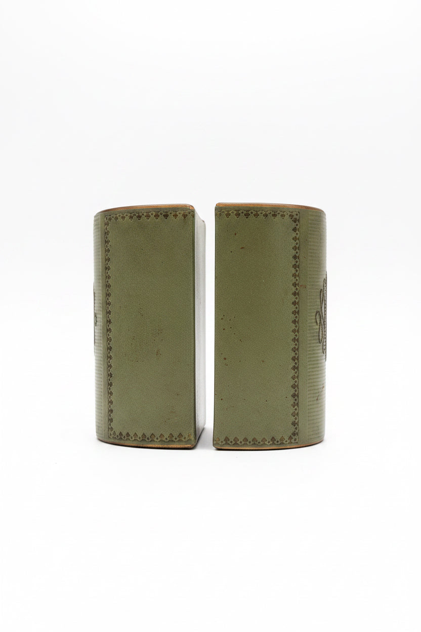Side profile of a pair of vintage sage green leather bookends, showcasing the smooth leather finish and decorative gold tooling along the edges.