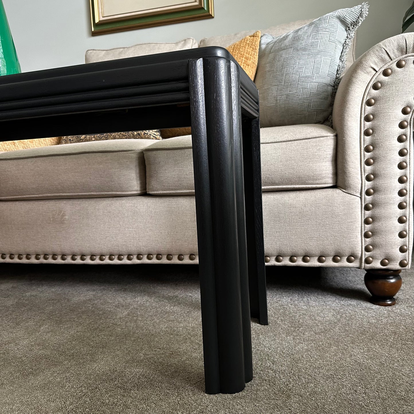 Side view of vintage black console table with fluted legs