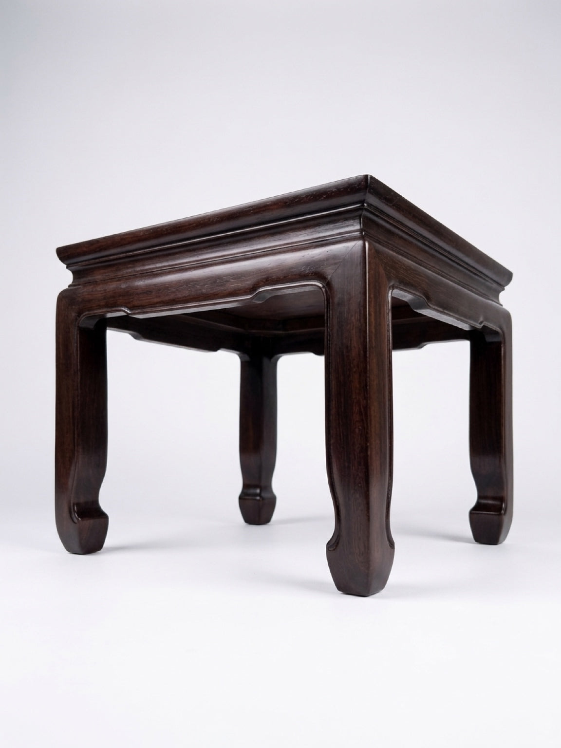 Square dark hardwood Ming-style low table with traditional inward-curving horse-hoof feet and a waisted apron frame, isolated on a clean white background.