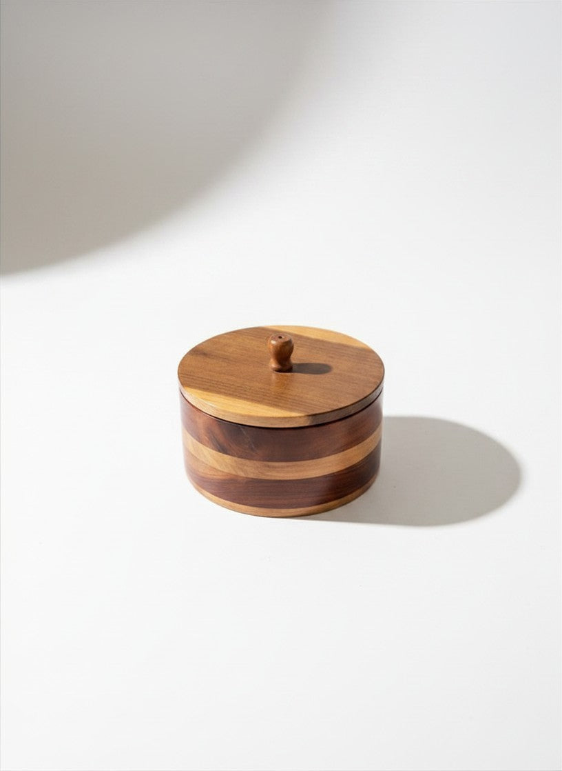 Side profile of a vintage circular lidded wood box showcasing alternating two-tone inlaid timber bands in walnut and honey tones.