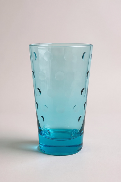 Turquoise glass with dot patterns on a light gray background

