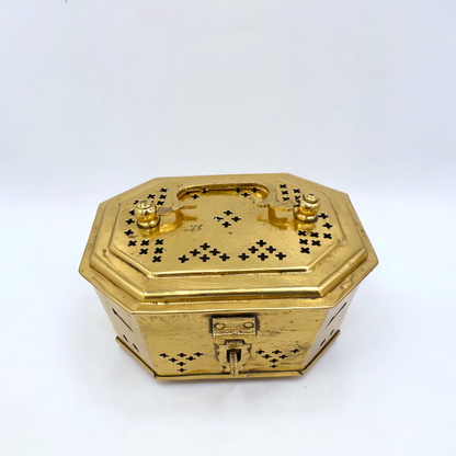 Gold octagonal jewelry box with intricate designs on a white background