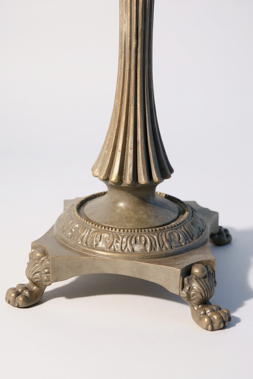 Decorative bronze pedestal with lion paw feet on a white background

