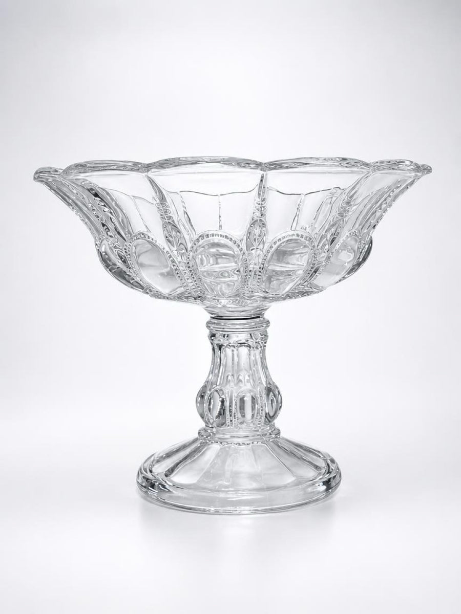 Studio profile shot of a vintage Early American Pattern Glass (EAPG) clear pedestal compote bowl in the "Beautiful Lady" pattern by Bryce Higbee, featuring a detailed multi-sided pedestal base and flared rim.