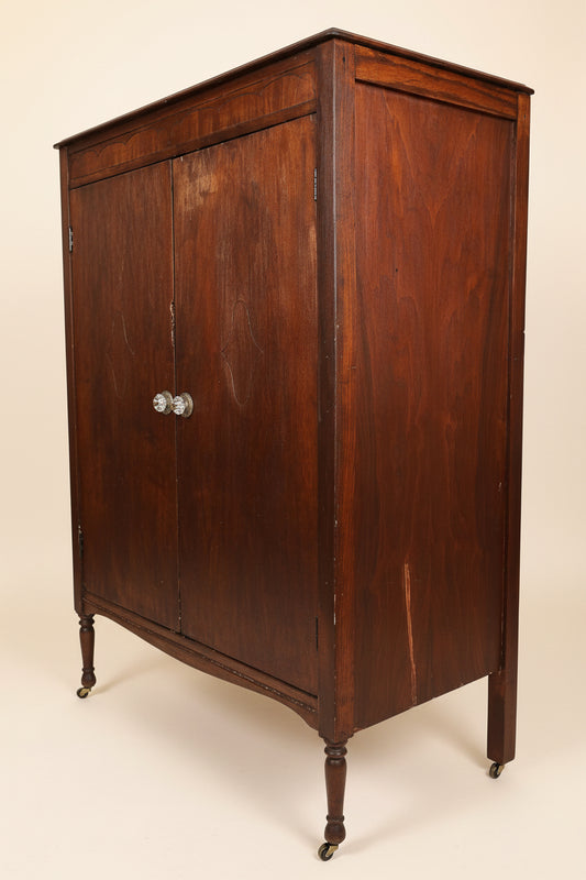 Wooden sideboard in a room with a sofa and framed picture on the wall.
