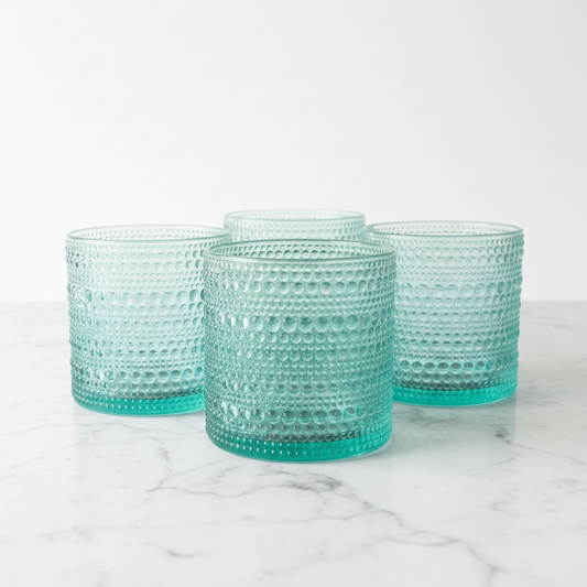 Set of four aqua blue hobnail double old fashioned rock glasses arranged on white marble, Home Essentials Halo collection