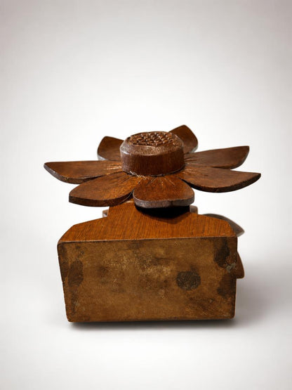 Top-down angled view showing the underside of a vintage wooden napkin holder base, highlighting the authentic aged wood patina and the top of the hand-carved retro flower petals.