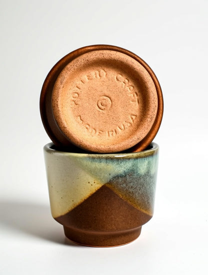 Bottom view of a vintage Pottery Craft tumbler showing the authentic "Pottery Craft Made in USA" stamp and the characteristic unglazed sand-textured stoneware base.