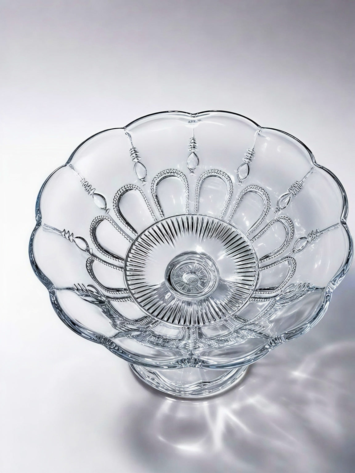 Top-down view of an antique Bryce Higbee "Beautiful Lady" clear pattern glass pedestal compote bowl, showing the intricate beaded gothic arches, rayed center, and scalloped rim details.