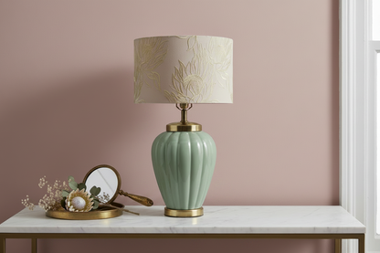 Vintage celadon ceramic table lamp styled on a white marble console table against a dusty rose pink wall with a brass tray, antique hand mirror, and dried protea and eucalyptus botanicals, warm natural window light — shade shown for styling inspiration, not included