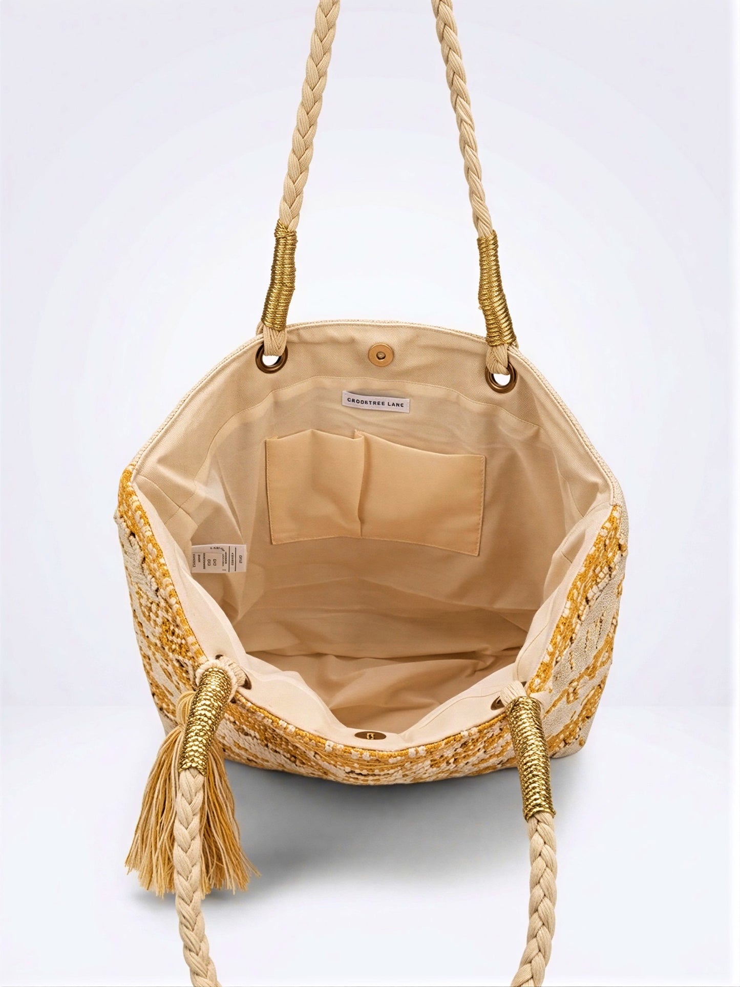 Top-down view of the Crosstree Lane woven tote bag wide open, highlighting its exceptionally ample interior capacity, canvas lining, interior pockets, and braided rope straps.