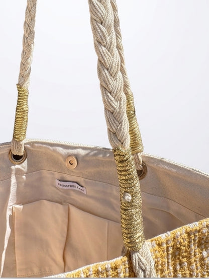 Close-up of the interior canvas lining on the Crosstree Lane tote bag, showcasing dual slip pockets, a metallic gold handle wrap, a magnetic snap closure, and the brand label.