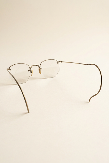 Eyeglasses with unfolded cable temples on an ivory background