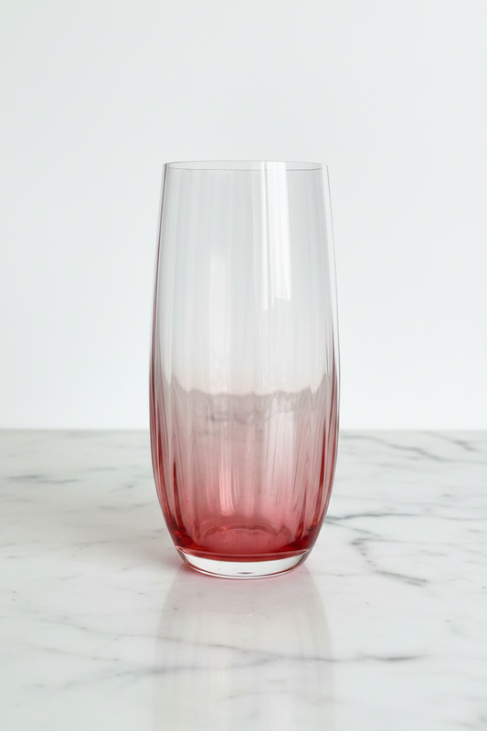 Single blush rose ombre highball glass on white marble, full profile view showing clear-to-deep-rose gradient and optic rib detail