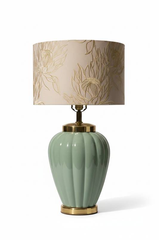 Vintage 1980s celadon glazed ceramic table lamp base in lobed melon urn form with polished brass shoulder collar and brass plinth, shown with embroidered cream botanical drum shade for scale on white background — shade not included