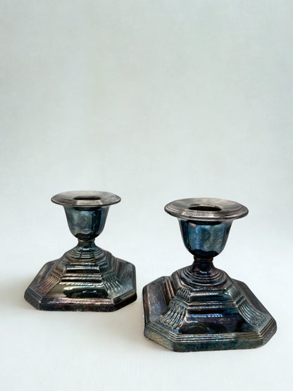 Two metallic candle holders on a white background