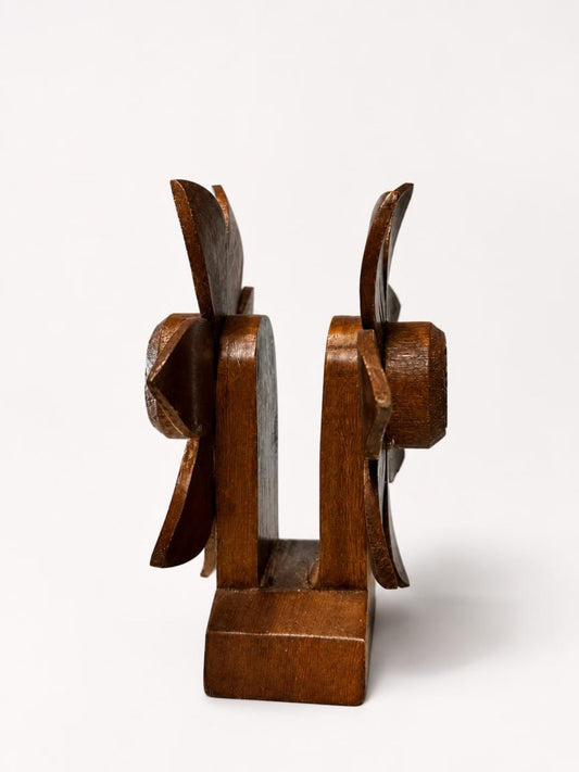Side profile view of a mid-century carved wood floral napkin holder, showcasing the thick dual flower panels, the central napkin slot, and the sturdy wooden base on a white background.