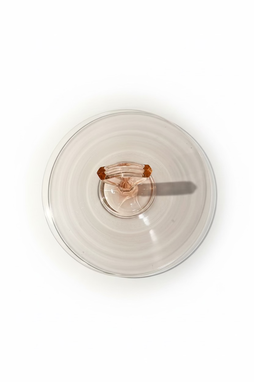 Overhead top down view of a circular ten inch pink Depression glass server showing the outer rim and center handle alignment.