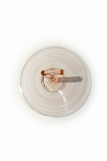Overhead top down view of a circular ten inch pink Depression glass server showing the outer rim and center handle alignment.