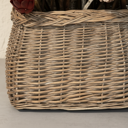 Close-up detail of hand-woven grey-wash reed basket showing tight horizontal weave pattern with plaited herringbone rim border and warm natural reed texture in muted grey and sand tones