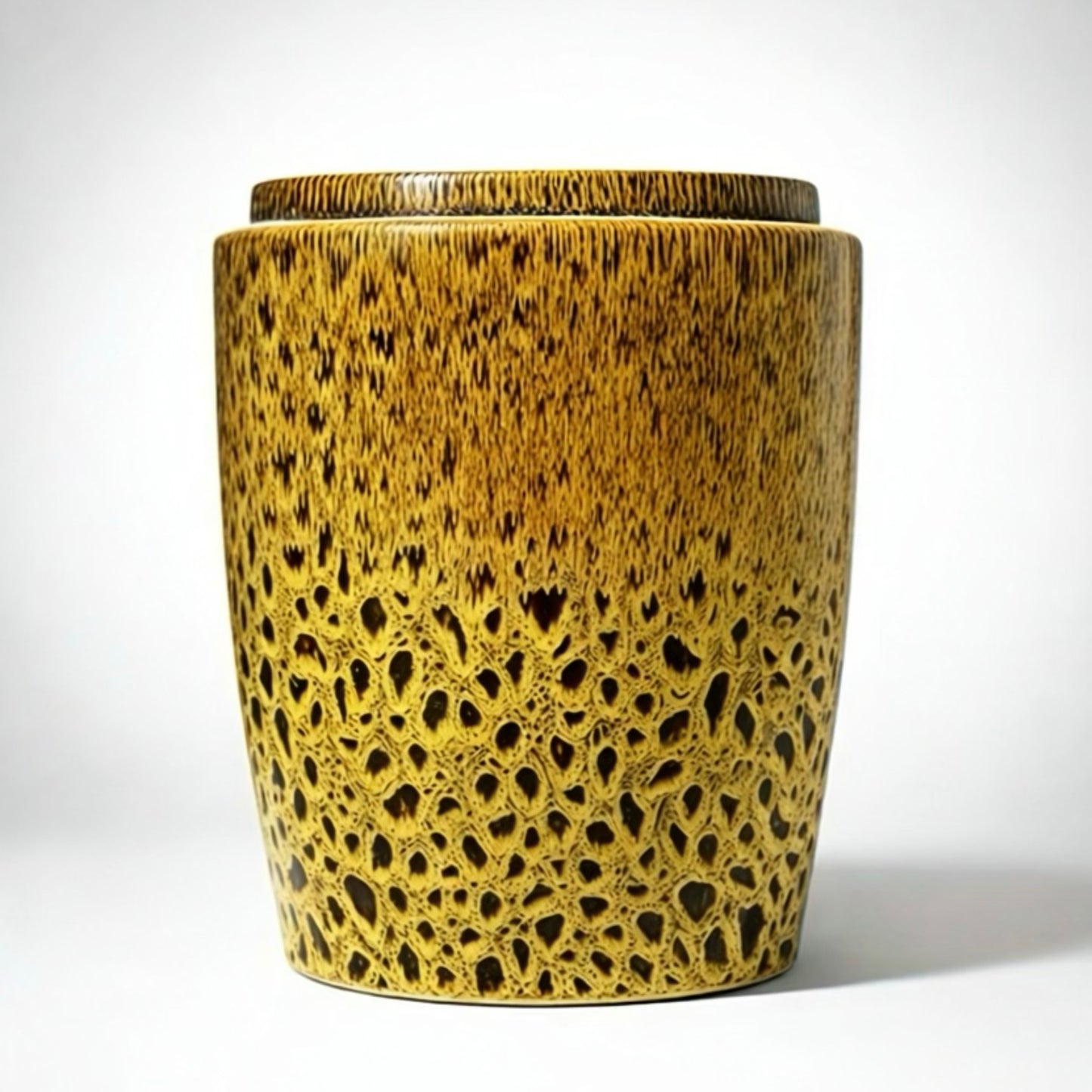 Cylindrical ceramic vase with textured surface on a white background